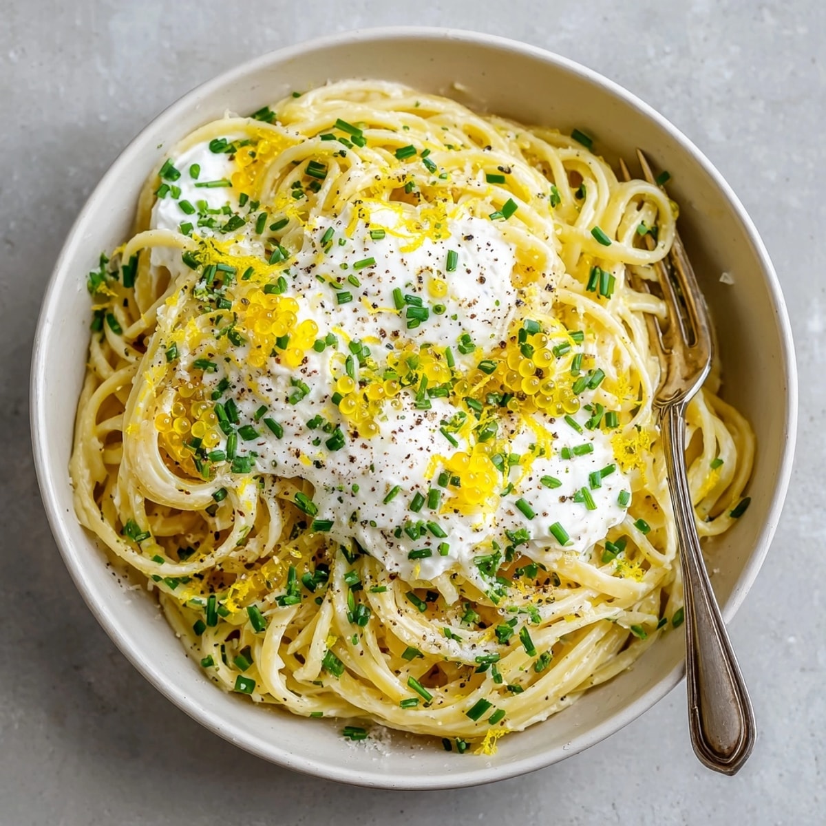 This close-up showcases Lemon Ricotta Pasta, a creamy delight with lemon caviar, ready to eat.