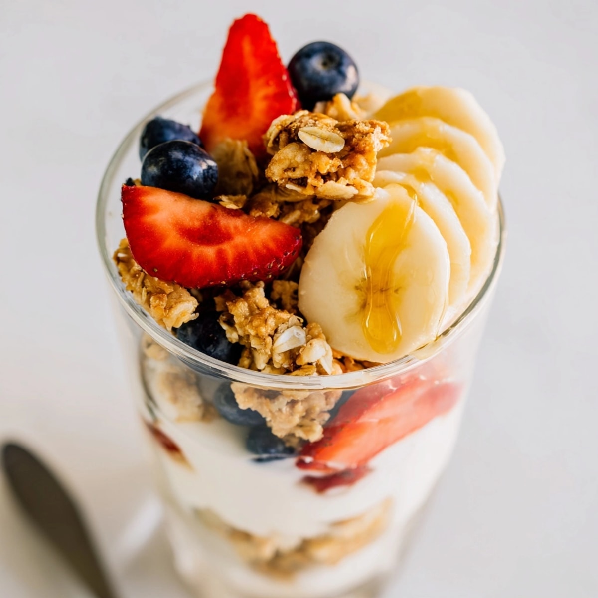 Yogurt Parfait layers: creamy yogurt, ripe berries, crunchy granola, ready to eat.