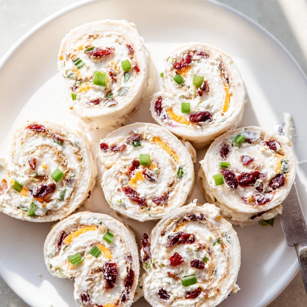 Creamy cranberry jalapeño cream cheese pinwheels served on a festive platter.  