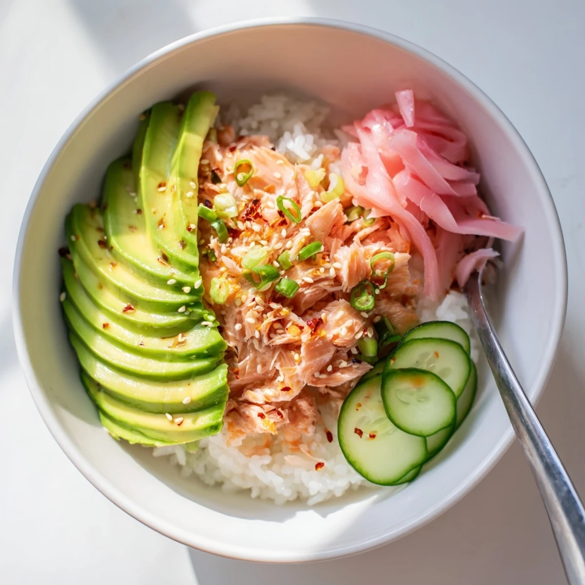 Delicious leftover salmon and rice bowl garnished with fresh avocado and cucumber.  