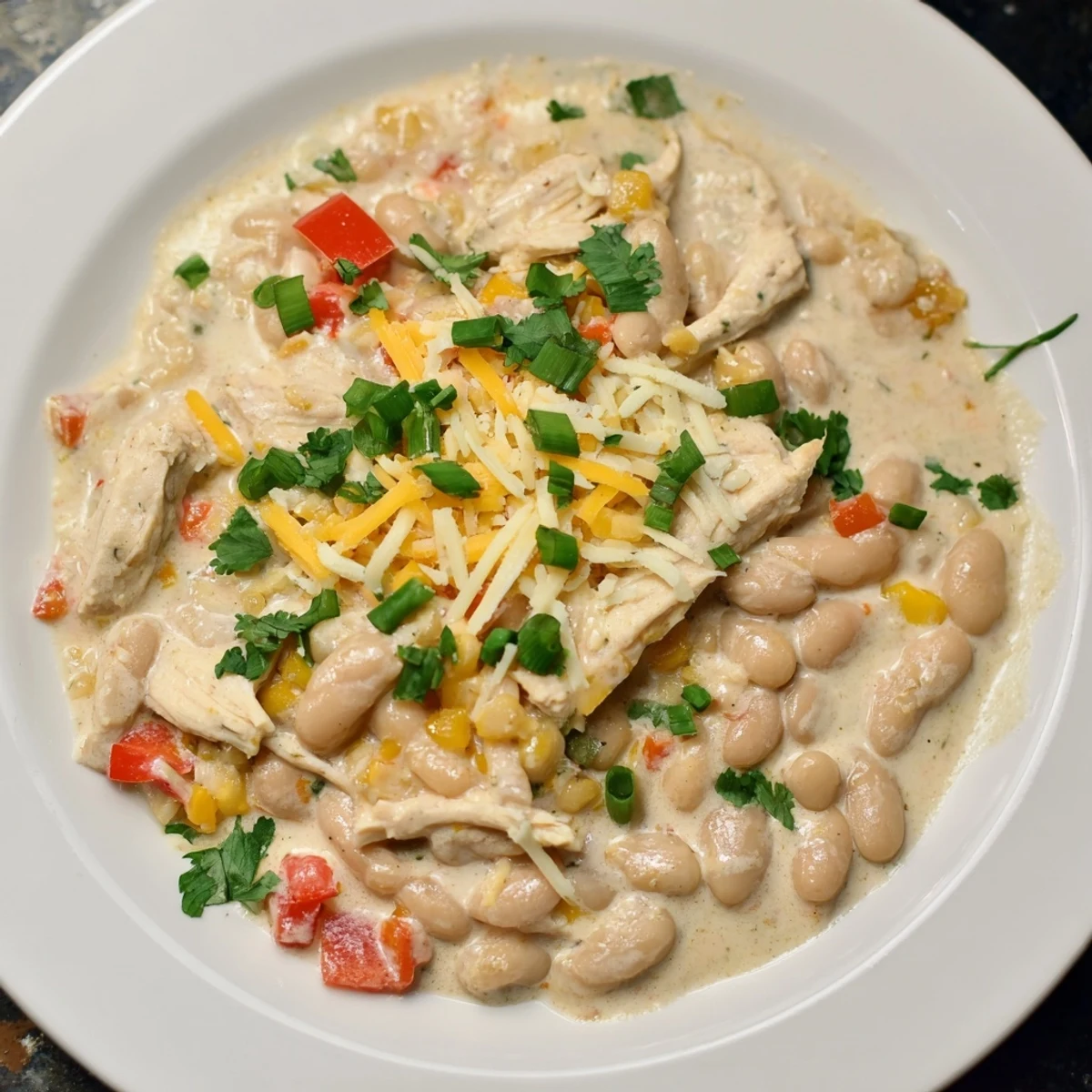 A large pot of bubbling Creamy White Chicken Chili with beans, ready to spoon into warm bowls.