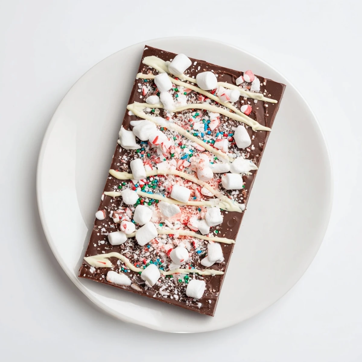 Close up image of Viral Hot Chocolate Bomb Bark, showcasing white chocolate drizzle over cocoa and marshmallows.
