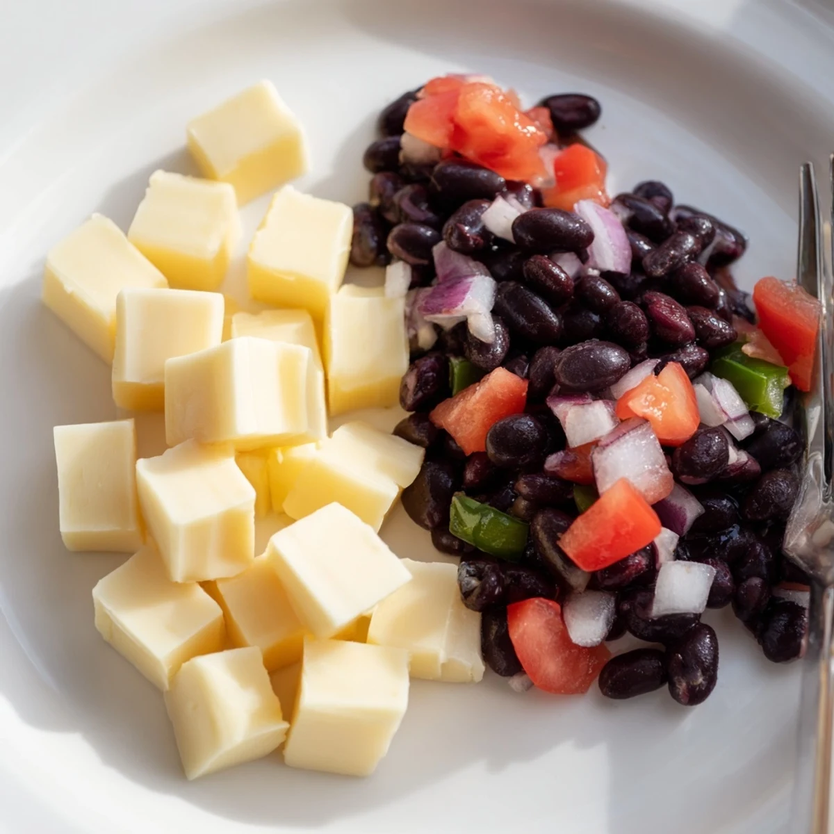 Pepper Jack cubes nestled near vibrant black bean salsa, perfect for a savory bite.