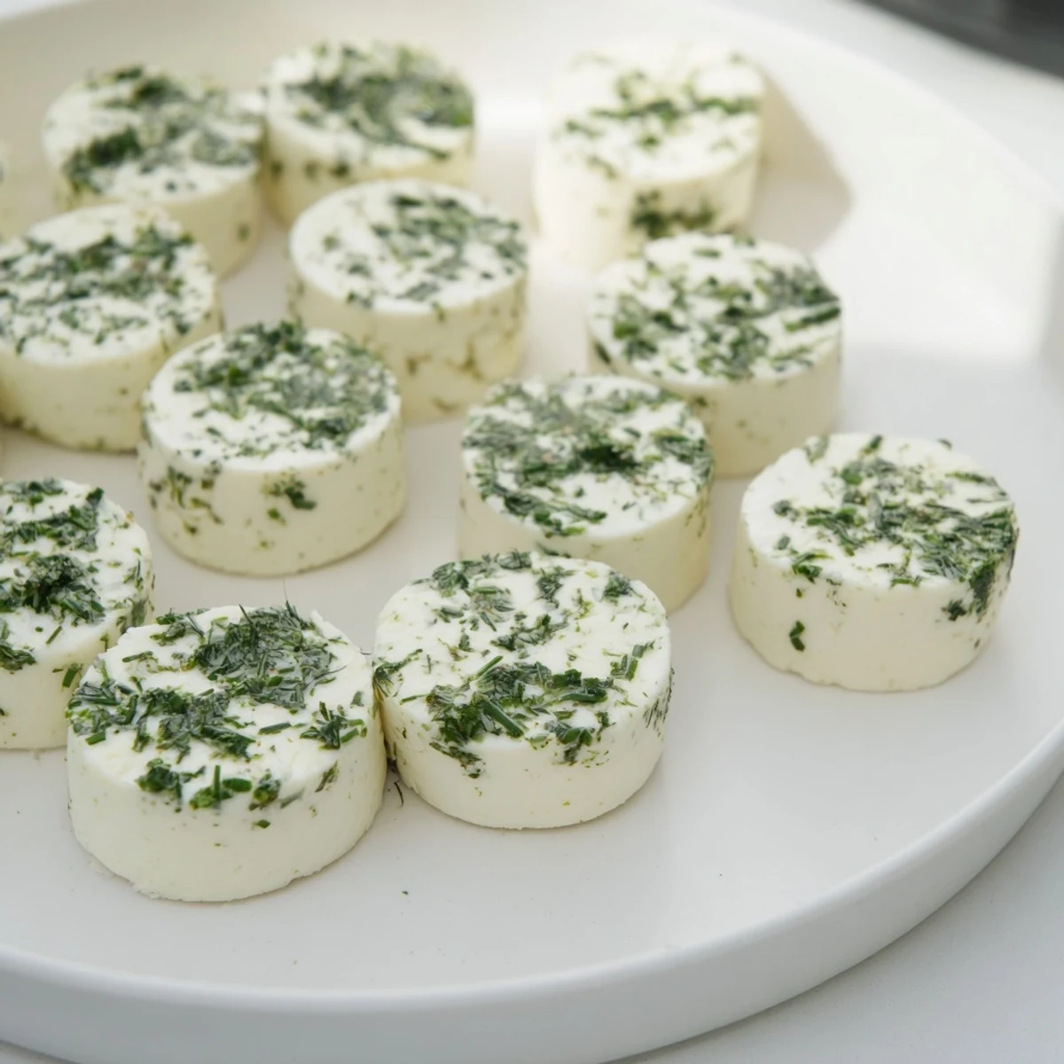 The Mossy Stone appetizer: Creamy goat cheese rolled in fresh herbs, ready for a cheese platter.
