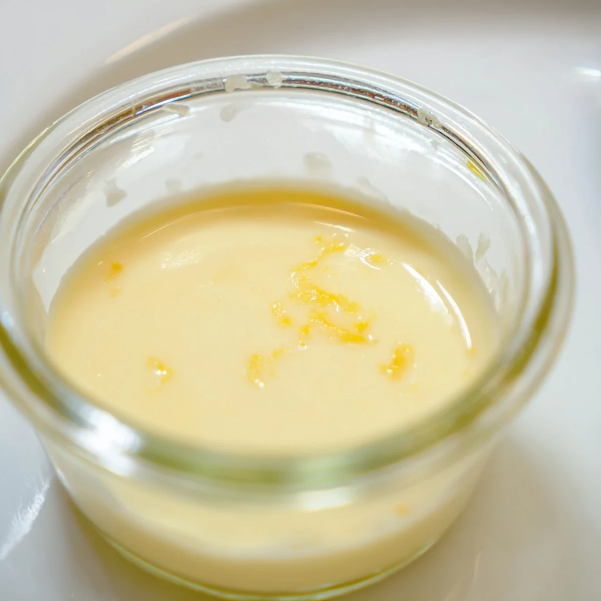 Silky smooth, light yellow 3-Ingredient Lemon Posset, garnished with lemon zest, the perfect dessert.