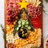 A festive Christmas Tree Snack Board, showcasing colorful grapes, cheese cubes, and sliced meats, ready to enjoy.