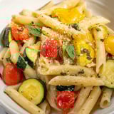 Hearty Garden Veggie Pasta with al dente penne tossed in a light, silky sauce, garnished with fresh basil and lemon zest.  
