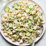 A close-up of creamy Cucumber Crunch Pasta Salad garnished with chopped dill and sliced green onions, ready for a summer picnic.