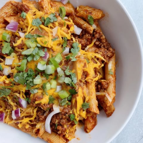 Easy Beef Enchilada Pasta, a one-pot meal, features tender beef, pasta, melted cheddar, and bold enchilada sauce.