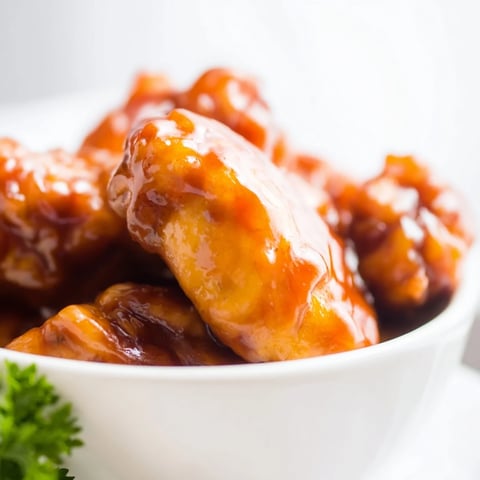A close-up of Sweet Chili Chicken Bowl with glossy chicken glazed in tangy-sweet sauce over fluffy rice and steamed broccoli.  