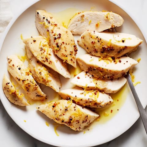 Tender chicken breasts drizzled with lemon juice and cracked black pepper, ready to serve.  
