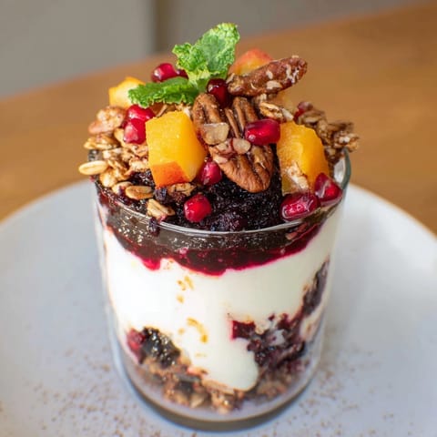 Festive Christmas Pudding Yogurt Parfait Bar with colorful fruit compotes and crunchy toppings, ready to enjoy.