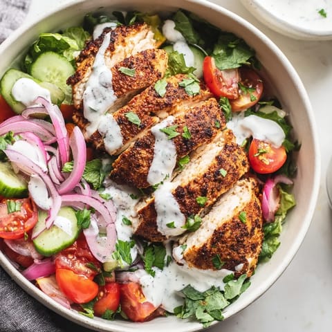 Vibrant Chicken Shawarma Salad Bowl for a healthy lunch, featuring golden sliced chicken and fresh parsley on a bed of mixed greens.  