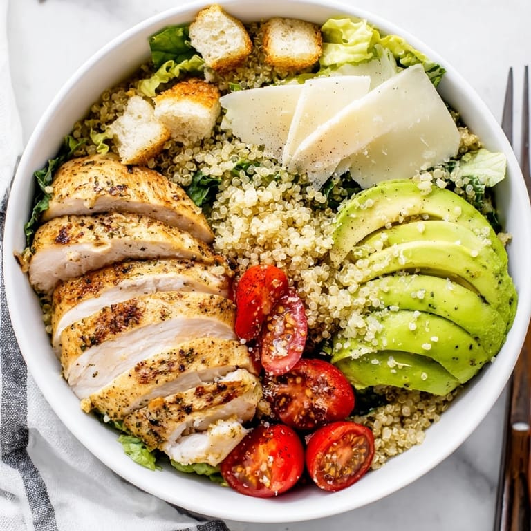 Hearty homemade Avocado Chicken Caesar Grain Bowl, drizzled in creamy dressing—a delicious, healthy feast.