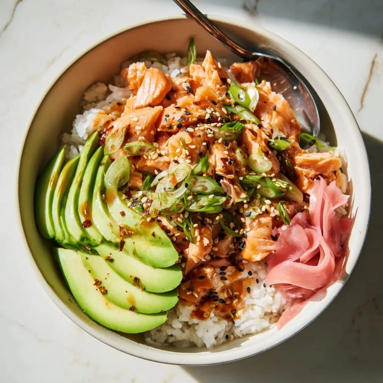 Revived leftover salmon and rice bowl with vibrant toppings and savory soy sauce drizzle.